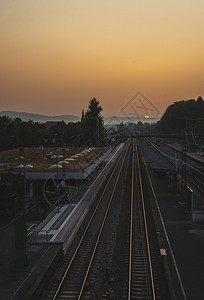 日出时火车站和铁路通往地平线的铁路清晨阳光明亮图片