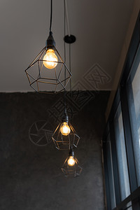 黑钢笼中的灯泡挂在咖啡店的天花板上现代风格的时装灯具和上图片