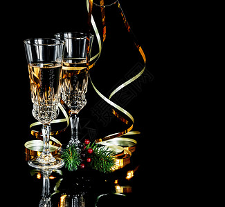 两杯香槟晶和两金色蛇纹在黑背景上隔离有文字空间图片