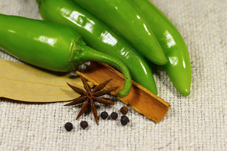 绿色辣椒与印度香料的近视隔绝在布料上图片