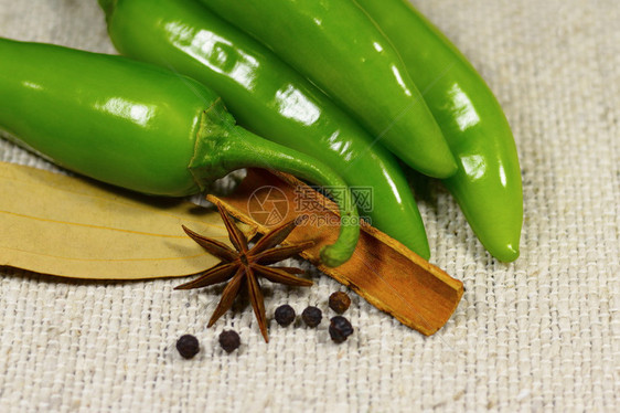 绿色辣椒与印度香料的近视隔绝在布料上图片