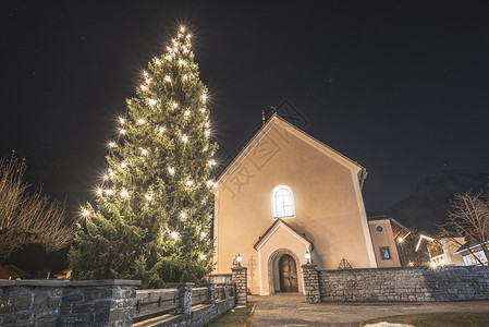 奥斯特里亚州ehrwald的圣诞节风景树教堂和灯光奥斯特里亚村的户外圣诞节装饰背景图片