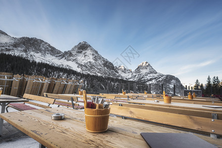 冬季风景与户外餐厅配有木桌和雪覆盖的山峰澳洲丘在十二月奥斯特里亚河的hrwald图片