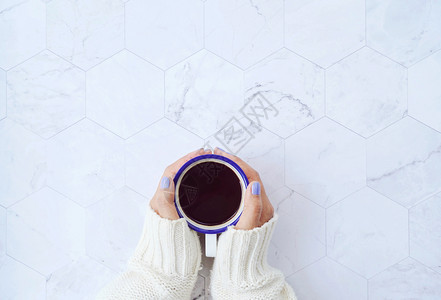 白色大理石背景的热咖啡冬季温暖的毛衣概念图片