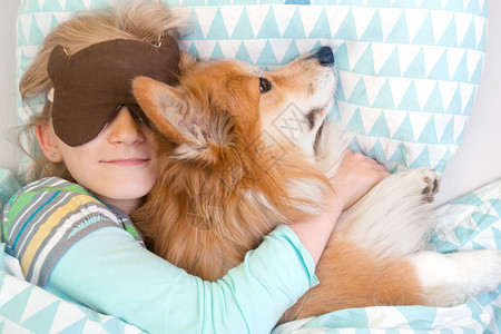 小女孩和狗狗抱着一起睡图片