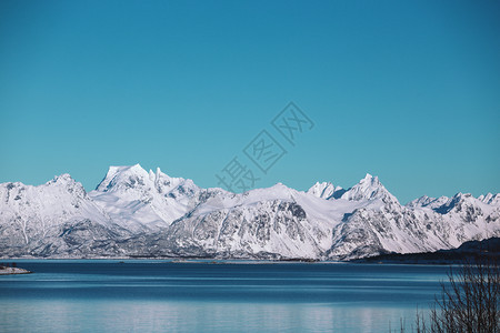 美丽的雪山及其在峡湾的反射渐变蓝的天空图片