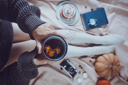 女孩拿着茶杯包子南瓜苹果书本耳机反光相图片