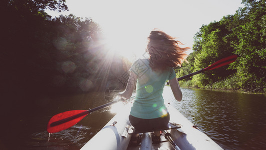 夏季和活跃的体育动日落时女孩皮艇图片