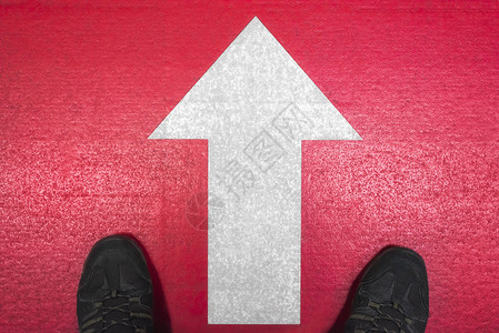 男子鞋站在白箭指向前方红色混凝土背景退出箭头动机概念向前移动符号图片