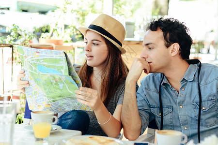 年轻旅游夫妇正在餐厅看旅行概念图片