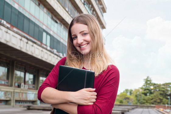 年轻女学生在大校园里自信的微笑图片