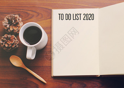 将20年清单列入工作空间台平面照片上咖啡和笔记本放在桌木背景上新年决议概念图片