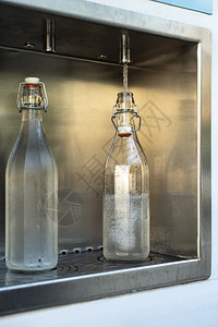 在街上装矿泉水从一个放器上装填矿泉瓶支付和装满饮用水图片
