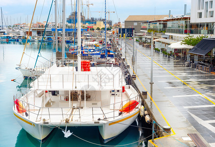 底栖动物游艇和机船停泊在有咖啡馆和餐的利马索码头雨季吉卜鲁图片