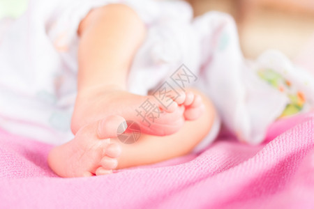 轻柔的新生婴儿脚对着粉红色的毯子图片