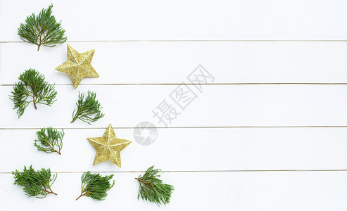 圣诞快乐组成金色星白木本底的松树枝图片