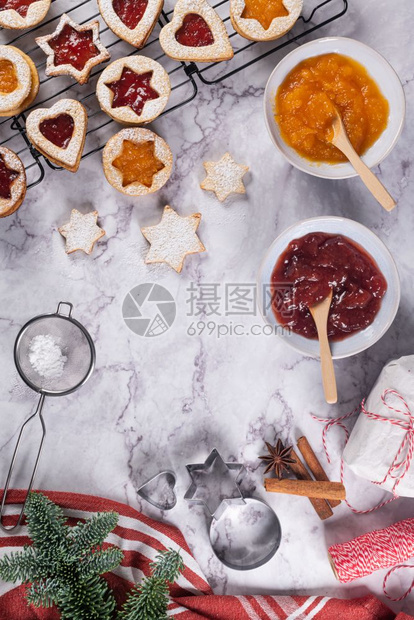 在大理石表面躺着有圣诞饼干的平板有圣诞装饰松树枝果酱礼品和饼干切机图片