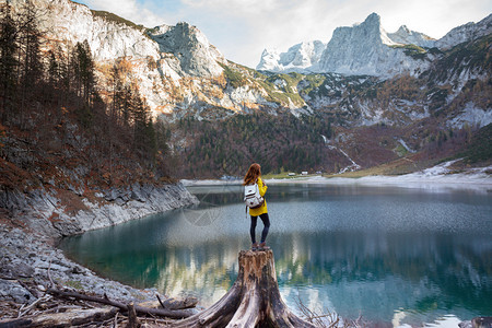 背包女孩站在山湖岸边图片