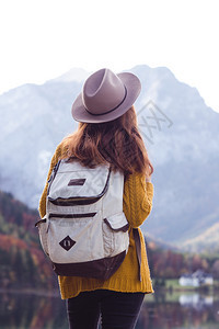 背包女孩站在山湖岸边图片