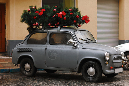 灰色复古甲壳虫车顶上载着圣诞树图片