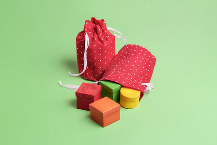 红色圣诞礼物袋上面有绿色背景的彩礼品盒圣诞物概念多色的圣诞礼物装在可爱的袋子里圣诞礼物图片