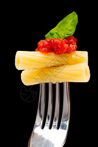 黑背景的意大利面西红柿和叉子上的巴西尔背景图片