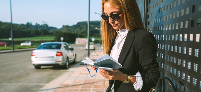 商业女人在街头阅读日记中工作图片