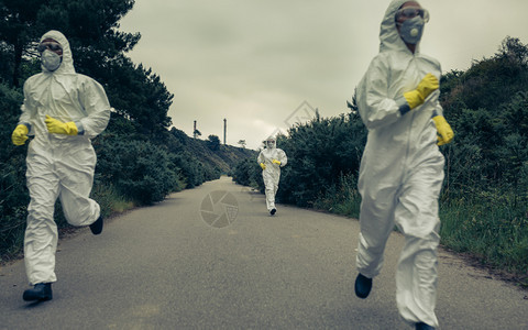 有细菌防护服的人跑在一条孤单的路上带着细菌防护服的人跑来去图片