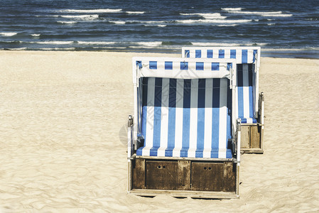 北海锡尔特岛德国的白沙滩上边椅暑假有蓝水海浪和沙椅阳光明媚的沙滩日图片