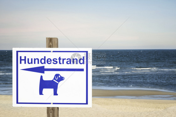 锡尔特岛海岸的狗沙滩北海德意志在阳光明媚的夏季日子里指导狗沙滩的标志在德国岛的狗友好海滩图片