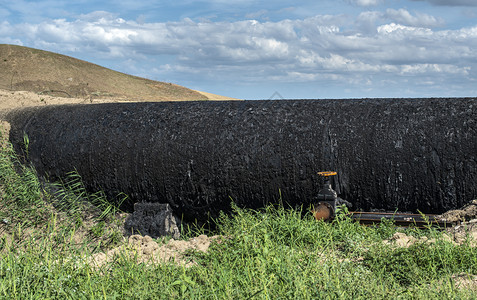 含油管道石汽运输概念绿色草黑油管水龙头图片