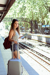 在车站的平台上的年轻旅游妇女图片