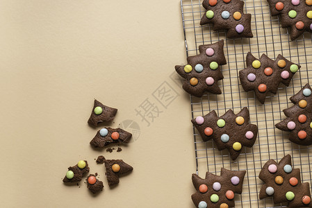 在冷却架上黄色背景以装饰智能的圣诞树形状巧克力姜饼干形状用巧克力姜饼干来烤概念图片