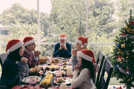 圣诞节一家人坐在餐桌前握手许愿图片