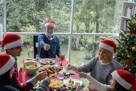 庆祝圣诞节晚宴在餐厅与圣诞树一同盛装庆祝圣诞节日家庭快乐的概念背景图片