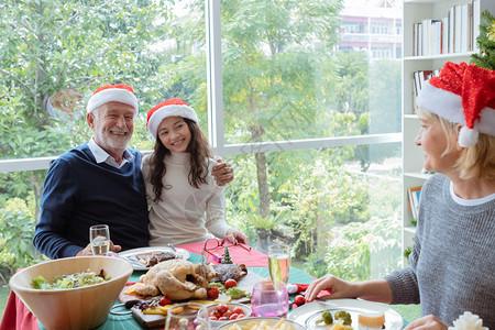 快乐的家庭爷微笑和拥抱女儿的小孩并一起庆祝圣诞节在餐厅的圣诞节图片