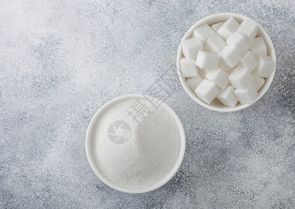白碗盘天然糖块和浅底色精制糖顶部视图图片