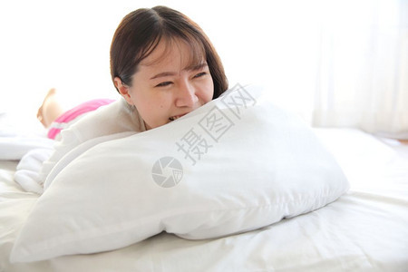 年青的女人醒来躺在白调的床上图片
