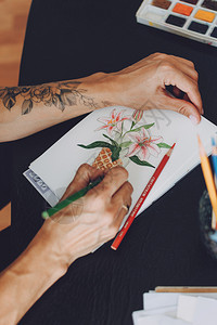 女艺术家在桌边画图的花朵包括绘画用品kropivntskyuranesptmbr08219图片
