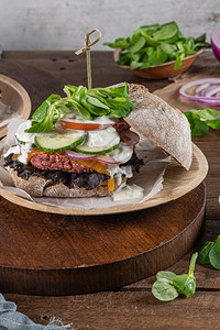 健康的素食汉堡新鲜蔬菜和酸奶酱在生锈的厨房柜台顶端图片