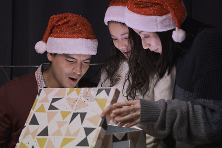 一家人在圣诞节晚上一起打开礼物箱图片