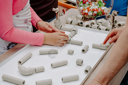 儿童在室内活动游戏和创造概念儿童在玩有趣的隧道和管塑料块装袋有满水管的饰龙头以制造扭曲转动建筑图片