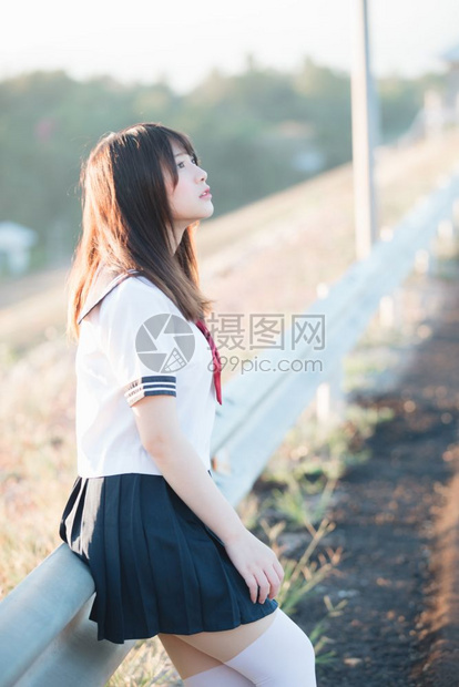 带着步行道和河边微笑的日本女学生制服图片