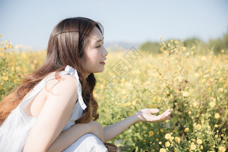 坐在花园里微笑着的年轻亚洲女孩肖像图片