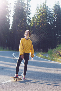 夏天的公路旅行美丽的风景和山路色女孩骑着滑板在横贯阿尔卑斯山罗马尼亚图片