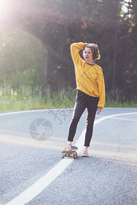 夏天的公路旅行美丽的风景和山路色女孩骑着滑板在横贯阿尔卑斯山罗马尼亚图片