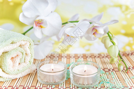 SPA概念浴巾两根蜡烛和一白兰花枝图片