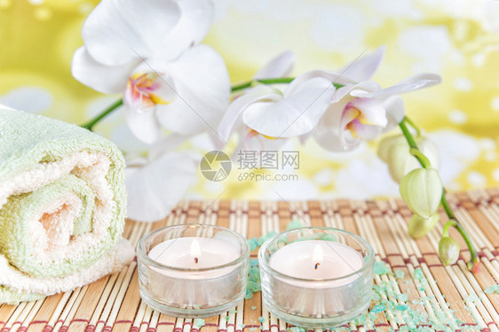 SPA概念浴巾两根蜡烛和一白兰花枝图片