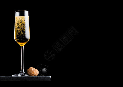 优雅的黄色香槟杯子黑大理石板上背景的软木和铁笼图片