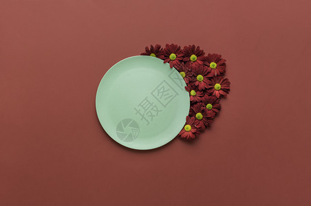 带有绿色空盘子和红花装饰品的弹簧桌设置红色背景生态友好的空盘子最起码的食物背景图片